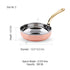 Copper and stainless steel fry pan with elegant brass handle on wooden table