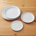 Stack of white melamine pizza plates for commercial kitchen use