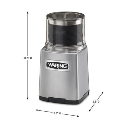 Waring commercial grinder grinding wet ingredients like garlic and ginger in clear-lid stainless steel bowl