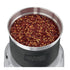 Waring WSG60 wet/dry grinder beside spice jars, herbs, and measuring spoons on kitchen counter