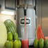 Waring juicer ejecting pulp into large container during continuous juice extraction